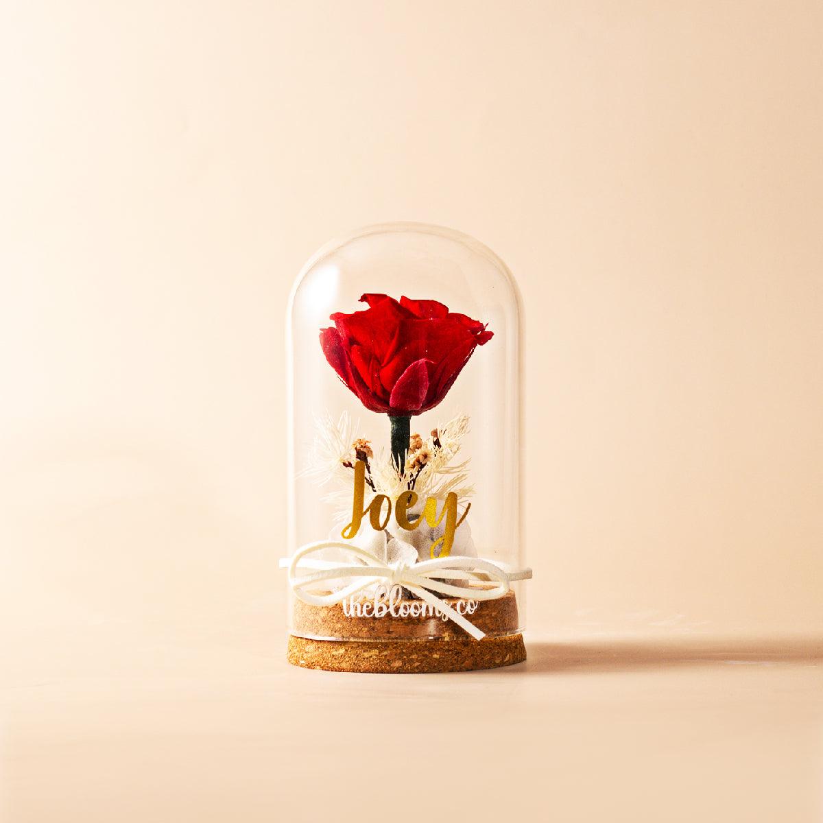 Red preserved rose in glass dome with name personalization, romantic floral gift for anniversary, birthday, or Valentine's Day.